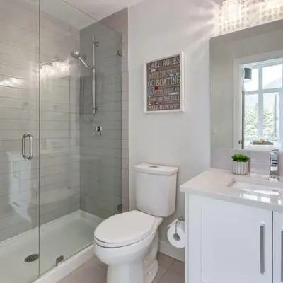 a white bathroom with a toilet and a shower at Stunning Modern 2BR Unit in Downtown Canmore in Canmore