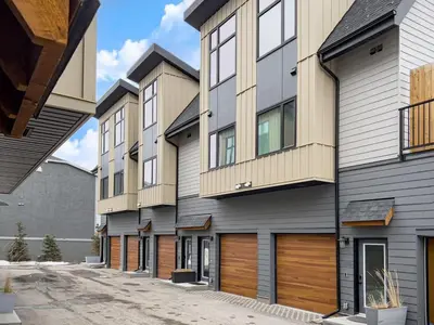 an apartment building with wooden garage doors at Stunning Modern 2BR Unit in Downtown Canmore in Canmore