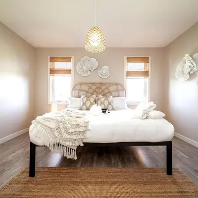 a bedroom with a large white bed with a rug at BoHo House-Sleeps 17-Garage-3 Kitchens-Fireplace in Edmonton