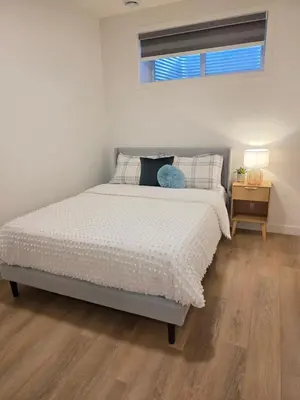 a bedroom with a bed and a window and a table at Amaville - One BRM Private Suite in West Edmonton in Edmonton