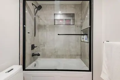 a bathroom with a bath tub with a shower at Metrotown area in Vancouver