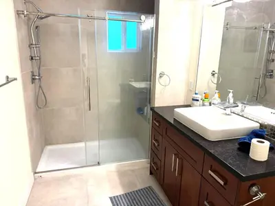 a bathroom with a shower and a sink and a mirror at W 20 House in Vancouver