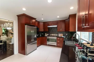 a kitchen with wooden cabinets and a stainless steel refrigerator at W 20 House in Vancouver