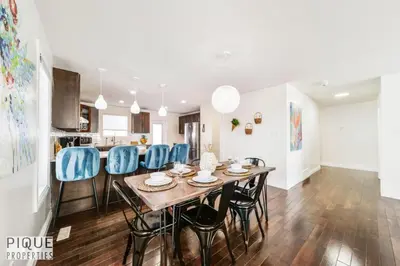 a kitchen and dining room with a table and blue chairs at Spacious 6BDR Oasis - Sleeps 17 - Garage - Fireplace in Edmonton
