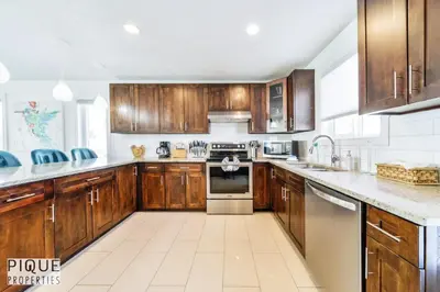 a large kitchen with wooden cabinets and appliances at Spacious 6BDR Oasis - Sleeps 17 - Garage - Fireplace in Edmonton