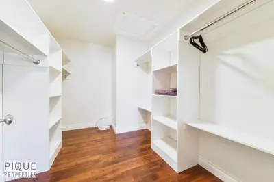 a walk in closet with white cabinets and wood floors at Spacious 6BDR Oasis - Sleeps 17 - Garage - Fireplace in Edmonton