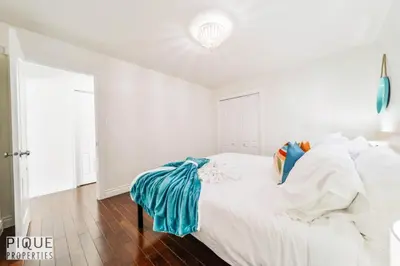 a white bedroom with a bed with white sheets at Spacious 6BDR Oasis - Sleeps 17 - Garage - Fireplace in Edmonton