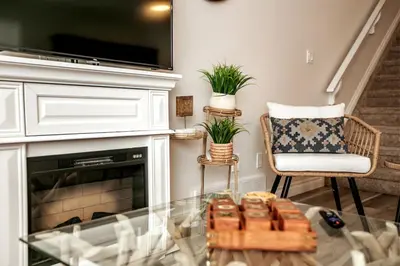 a living room with a fireplace and a glass table at Luxe Escape Duo - 8 Beds - Sleeps 22 - 4 Car Garage in Edmonton