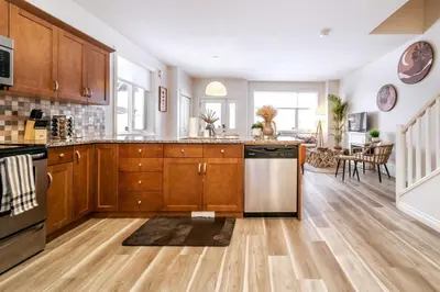 a kitchen with wooden cabinets and a stainless steel dishwasher at Luxe Escape Duo - 8 Beds - Sleeps 22 - 4 Car Garage in Edmonton