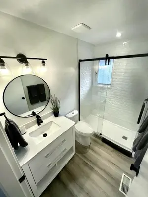 a bathroom with a white sink and a shower at Camelia Home in Kelowna