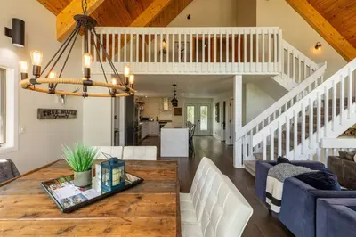 a dining room and living room with a wooden table at True North Chalet by Fernie Central Reservations in Fernie