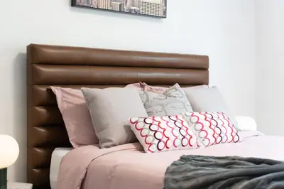 a bed with pink and grey pillows on it at Heritage Home in Heart of City with free Parking in Vancouver