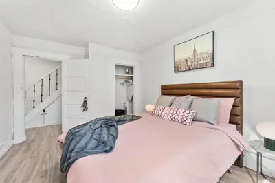 a bedroom with a large bed with pink sheets at Heritage Home in Heart of City with free Parking in Vancouver