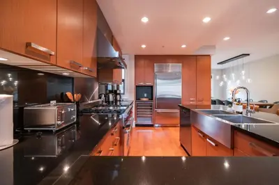 a kitchen with black counter tops and wooden cabinets at Fitzsimmons Walk 15 by Outpost Whistler in Whistler