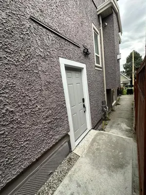 a white door on the side of a building at Bright New 2BR Suite Near YVR in Vancouver