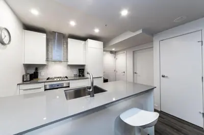 a kitchen with white cabinets and a sink at Corporate Stays Tate 1 Bedroom in Vancouver