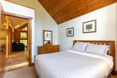 a bedroom with a white bed and a wooden ceiling at Black Diamond Chalet by Fernie Central Reservations in Fernie