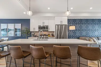 a kitchen with a large island with chairs around it at Classic Modern 4BR Nearby DT Hot tub and Pool in Canmore