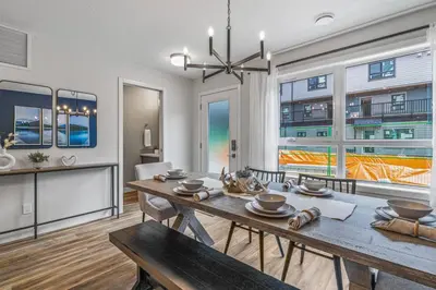 a dining room with a table and chairs and windows at Classic Modern 4BR Nearby DT Hot tub and Pool in Canmore