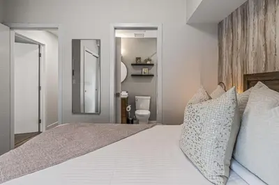 a bedroom with a large white bed with pillows at Classic Modern 4BR Nearby DT Hot tub and Pool in Canmore