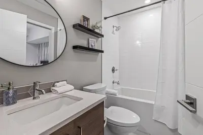 a bathroom with a sink and a toilet and a mirror at Classic Modern 4BR Nearby DT Hot tub and Pool in Canmore