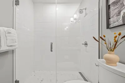 a bathroom with a toilet and a glass shower at Mountain Modern 2BR Townhome with Stunning View in Canmore