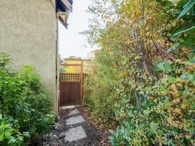 a garden with a fence and a wooden gate at Gallery Garden - stylish, art-filled 1-bedroom suite by Victoria Prime! in Victoria