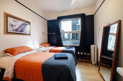 a bedroom with two beds and a window at The Guesthouse Vancouver Downtown in Vancouver