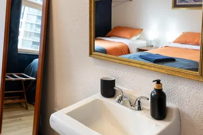a bathroom with a sink and a mirror at The Guesthouse Vancouver Downtown in Vancouver