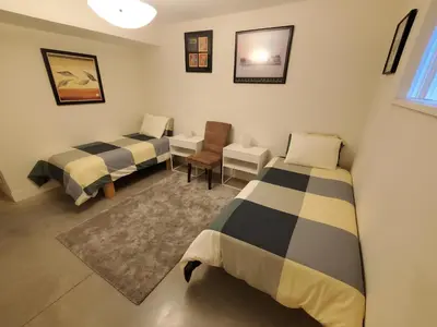 a room with two beds and a desk and a chair at Forest Hills in North Vancouver