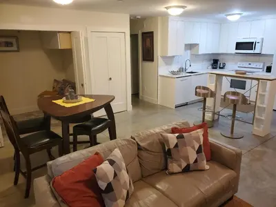 a living room with a couch and a table and a kitchen at Forest Hills in North Vancouver