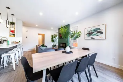 a dining room and living room with a table and chairs at 9BDRM Chic Luxury Retreat-Hot Tub-BBQ-Sleeps 23! in Edmonton