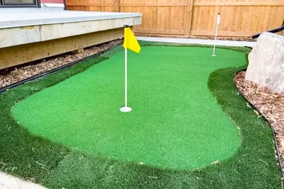 a miniature golf course with green grass and a yellow flag at 9BDRM Chic Luxury Retreat-Hot Tub-BBQ-Sleeps 23! in Edmonton