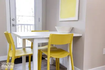 a dining room table and chairs with yellow chairs at Dual-Suite Getaway - Sleeps 12 - Whyte Ave - NFLX in Edmonton