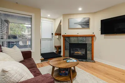 a living room with a couch and a fireplace at Private Hot Tub | Free Parking | Pool | Sauna in Whistler