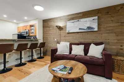 a living room with a couch and a table at Private Hot Tub | Free Parking | Pool | Sauna in Whistler