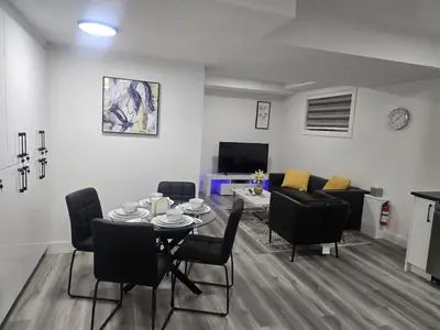 a living room with a table and chairs and a couch at L&D Luxury Suite in Nisku