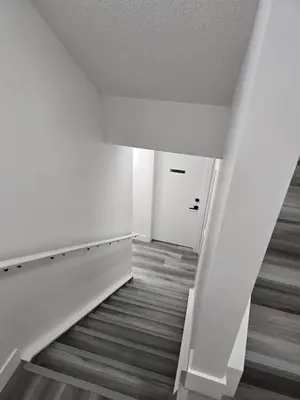 an empty room with a staircase and a white door at L&D Luxury Suite in Nisku
