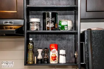 a shelf with various items on it in a kitchen at Bright Modern Suites-King Beds-NFLX-WiFi-LongStays in Edmonton