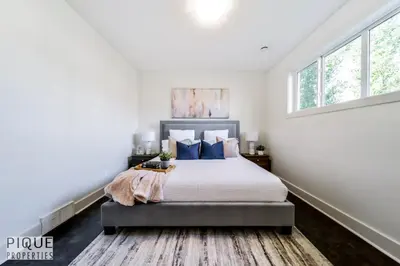 a bedroom with a large bed with blue pillows at Bright Modern Suites-King Beds-NFLX-WiFi-LongStays in Edmonton