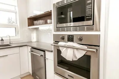 a kitchen with a stainless steel oven with a microwave at 5BDRM Chic Modern Home-Hot Tub-King Bed-AC-Garage in Edmonton