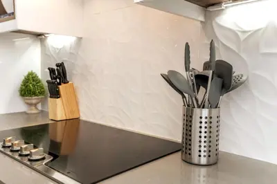a vase with utensils on a counter in a kitchen at 5BDRM Chic Modern Home-Hot Tub-King Bed-AC-Garage in Edmonton
