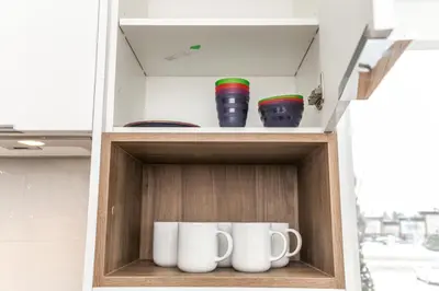 a cupboard with two mugs and three vases at 5BDRM Chic Modern Home-Hot Tub-King Bed-AC-Garage in Edmonton