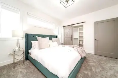 a bedroom with a green bed and a window at 5BDRM Chic Modern Home-Hot Tub-King Bed-AC-Garage in Edmonton