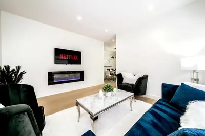 a living room with a couch and a table at 5BDRM Chic Modern Home-Hot Tub-King Bed-AC-Garage in Edmonton