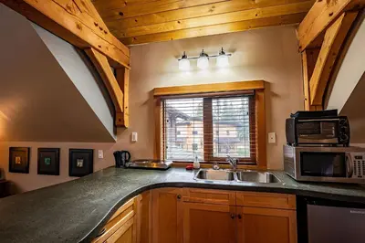 a kitchen with a sink and a microwave at Timberloft by Revelstoke Vacations in Revelstoke