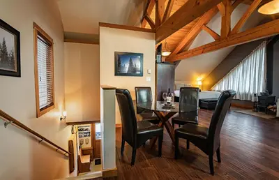 a dining room with a table and black chairs at Timberloft by Revelstoke Vacations in Revelstoke