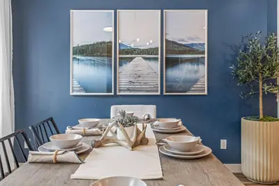 a dining room with a table with a view of a pier at Rockies Escape for Groups with Hot tub and Pool in Canmore