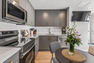 a kitchen with a table with a vase of flowers on it at Rockies Escape for Groups with Hot tub and Pool in Canmore