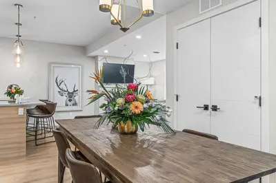 a dining room with a table with a vase of flowers at Spacious 3BR Haven in Scenic Canmore in Canmore